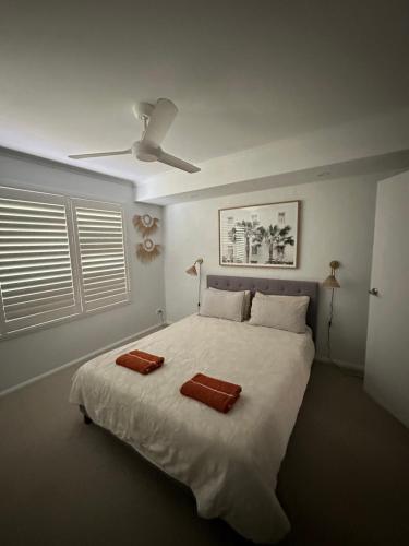 a bedroom with a large white bed with two towels on it at Wala Villa in Noosaville