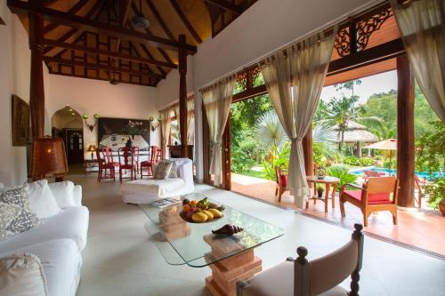 un soggiorno con divano bianco e tavolo di Villa Tropical Bliss Luxury Estate a Nathon Bay