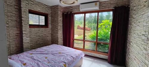 a bedroom with a bed and a large window at The iNow ไอหนาว เขาค้อ in Khao Kho