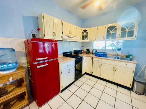 uma cozinha com um frigorífico vermelho e armários brancos em Casa Kante em San José del Cabo