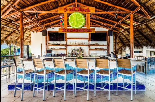 een bar met stoelen en een tafel met een limoen bord bij Margaritaville Beach Resort - Poolview - Costa Rica in Playa Flamingo