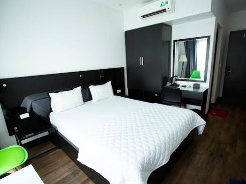 ein Schlafzimmer mit einem großen weißen Bett und einem Spiegel in der Unterkunft Ánh Hồng Hottel in Hanoi