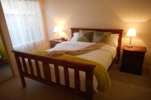 ein Schlafzimmer mit einem großen Bett mit zwei Lampen an Tischen in der Unterkunft Grace Cottage - Free Wi-Fi, Foxtel,Central Heating in Katoomba