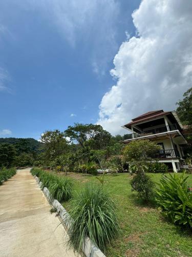 een gebouw naast een onverharde weg naast een veld bij Tamarind Villa in Kuah