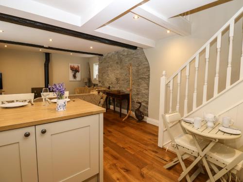 a kitchen and living room with a table and chairs at White Swan Cottage in Leyburn
