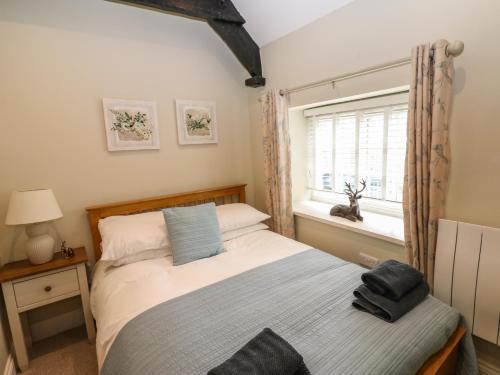 a small bedroom with a bed and a window at White Swan Cottage in Leyburn