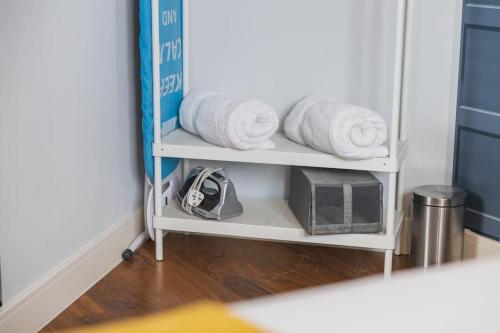 a shelf with towels and a microwave in a room at Five ways Modern Apartment in Birmingham