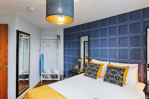 a bedroom with a large bed with a blue wall at Five ways Modern Apartment in Birmingham