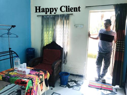 a man standing in a door to a happy client at Grand Mess in Comilla