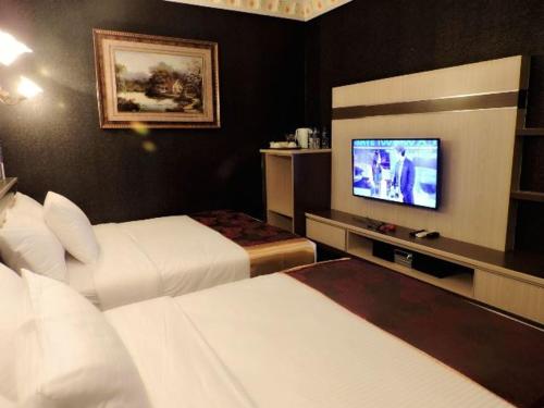 a hotel room with two beds and a flat screen tv at The Ardens Hotel - Nong Chik, Kolam Air, Johor Bahru in Johor Bahru