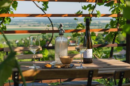 a table with two bottles and two glasses of wine at Buborék - Somló Country Home in Somlóvásárhely