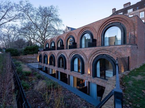 a brick building with arches on the side of it at The Arches Luxurious Three Bedroom Houses Close to Hampstead Heath with garden balcony and courtyard in London