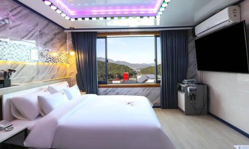 蔚山的住宿－Hotel Eat Dot Com Alpeuseu Oncheon，一间卧室配有一张大床和一台平面电视