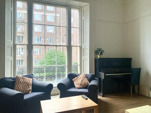 a living room with two couches and a piano at St Paul's Road Townhouse by Clifton Short Lets in Bristol
