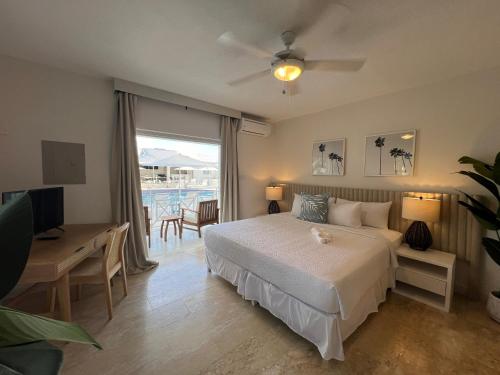 a bedroom with a bed and a desk and a television at South Point Hotel in Christ Church