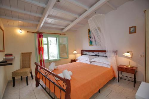 a bedroom with a bed with orange sheets and white pillows at Pelagos in Stafylos