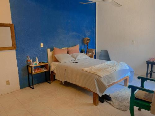 a bedroom with a bed and a blue wall at Casa lina in Puerto Escondido