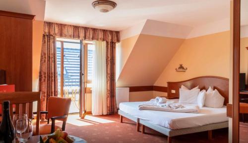 um quarto de hotel com uma cama e uma grande janela em Főnix Wellness *** 1 A épület em Hévíz