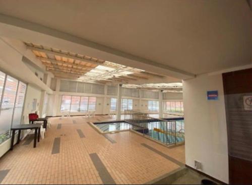 a large room with a swimming pool in a building at Depa Privado en Ambiente Residencial Piscina Gimnacio in Bogotá
