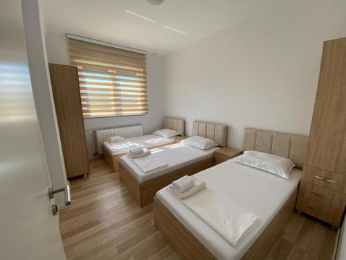 a room with three beds and a window at Tregu Fatoni #2 prizren city 3 bedroom apartment in Prizren