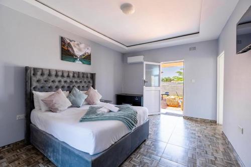 1 dormitorio con 1 cama grande en una habitación en The Crescent Victoria Falls en Victoria Falls