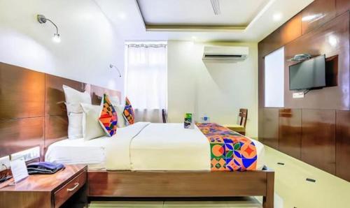 a bedroom with a bed and a desk and a tv at FabHotel Tipsyy Inn Suites in Jaipur