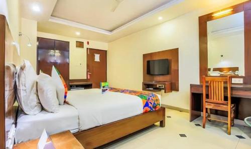 a bedroom with a bed and a desk and a television at FabHotel Tipsyy Inn Suites in Jaipur