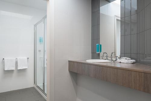 a bathroom with a sink and a shower at Sovereign Hill Hotel in Ballarat