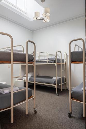 a room with three bunk beds and a ceiling at Sovereign Hill Hotel in Ballarat