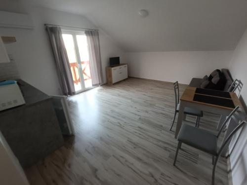 an empty living room with a table and chairs at Apartamenty Kwiat Jabłoni in Mikołajki