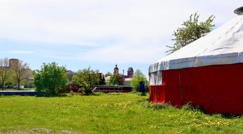 uma tenda vermelha e branca num campo de relva em Boot & Bike Hansestadt Anklam em Anklam