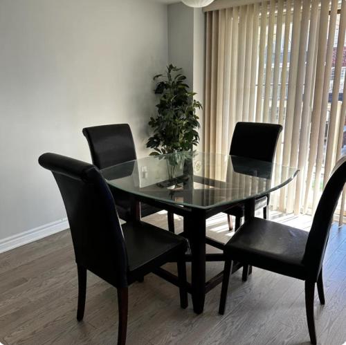 a dining room table with black chairs and a potted plant at Cozy Whitby Retreat in Whitby