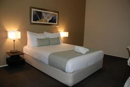 a hotel room with a large bed with two lamps at Aero Auckland Airport in Auckland