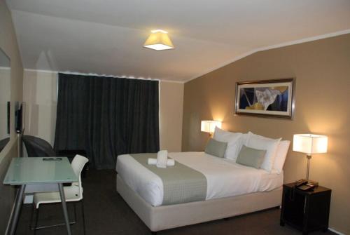 a hotel room with a large bed and a table at Aero Auckland Airport in Auckland