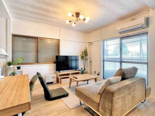 a living room with a couch and a tv at 旅家 Kanzakigawa in Osaka