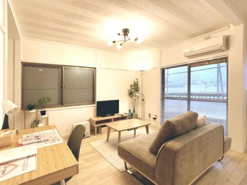 a living room with a couch and a table at 旅家 Kanzakigawa in Osaka