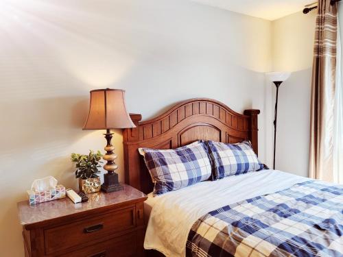 a bedroom with a bed and a lamp on a dresser at Bed Plus YVR in Richmond