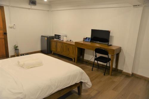 a bedroom with a bed and a desk with a computer at BPP Resident near Donmueang Airport in Ban Don Muang (1)