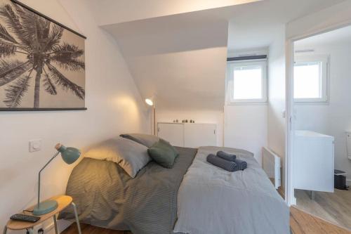 Un dormitorio con una cama y una lámpara. en Ty Chou - Appartement Cosy - Centre Ville, en Rennes