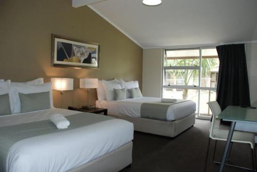 um quarto de hotel com duas camas e uma varanda em VR Auckland Airport em Auckland
