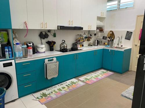 uma cozinha com armários azuis e um forno com placa de fogão em Qaisara Homestay em Kampong Alor Gajah