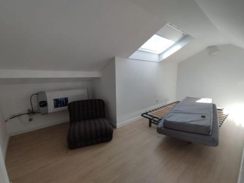 a room with a bed and a chair and a window at 28 Casa do Avô - 2Km from the beach in Sesimbra