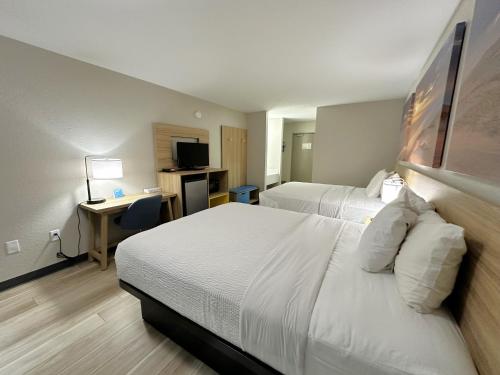 Habitación de hotel con 2 camas y escritorio en Days Inn by Wyndham Holland, en Holland