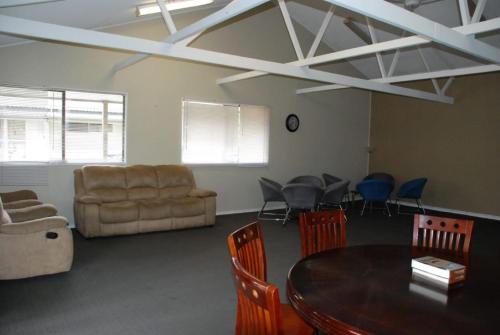a living room with a table and chairs and a couch at Aero Auckland Airport in Auckland