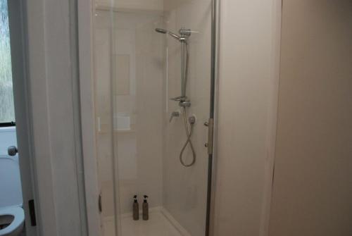 a shower in a bathroom with a glass door at Aero Auckland Airport in Auckland