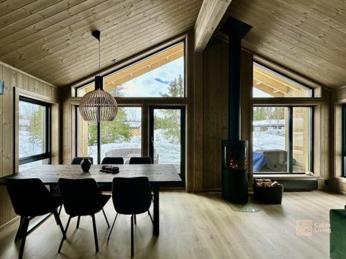 a dining room with a large wooden table and chairs at Brand new cabin in the center of Skeikampen in Svingvoll