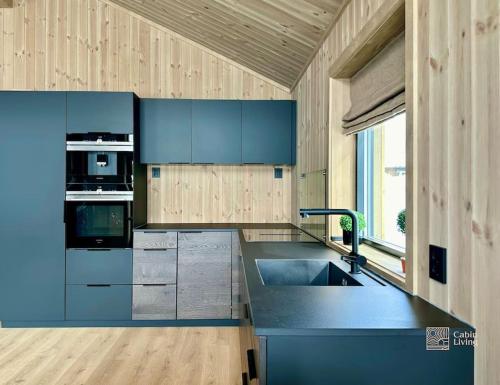 a kitchen with blue cabinets and a sink at Brand new cabin in the center of Skeikampen in Svingvoll