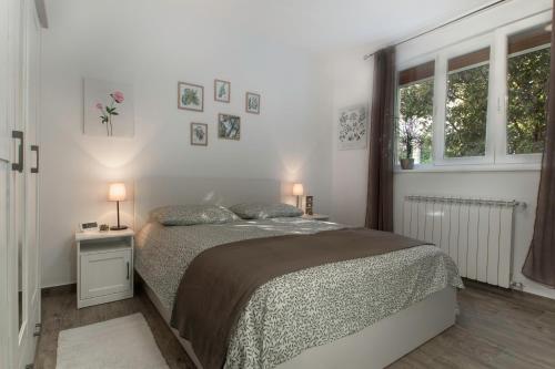 una camera bianca con un letto e due finestre di Apartment Vinotoč Izola a Izola