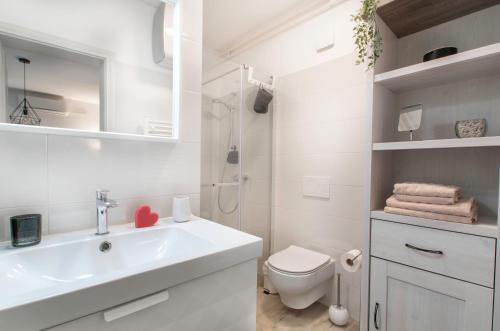 bagno bianco con lavandino e servizi igienici di Apartment Vinotoč Izola a Izola