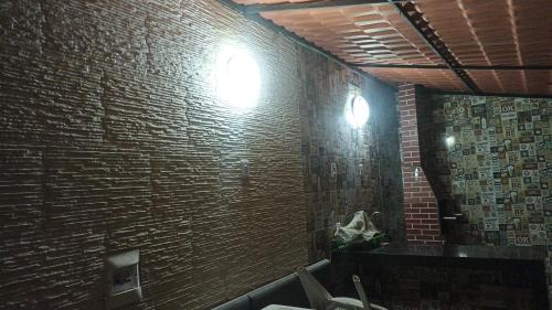 uma casa de banho com uma parede de tijolos e um espelho. em O melhor refúgio para o FIG 2024 em Garanhuns